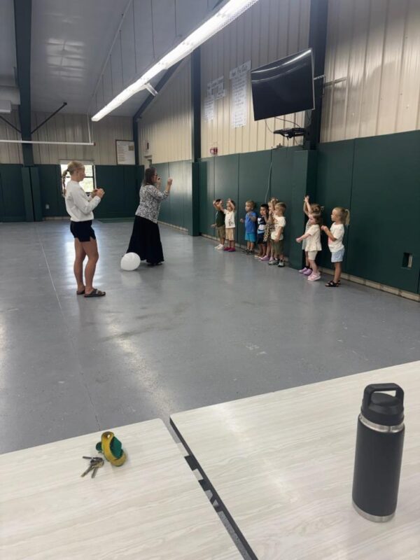 Dr. Coffey, Seniors, and AM Preschoolers playing balloon volleyball.