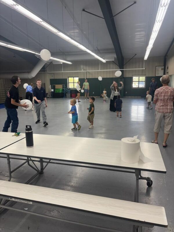 Dr. Coffey, Seniors, and AM Preschoolers playing balloon volleyball.