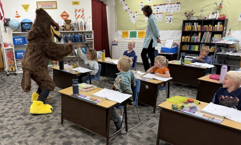 New Hawk mascot giving student a high-five