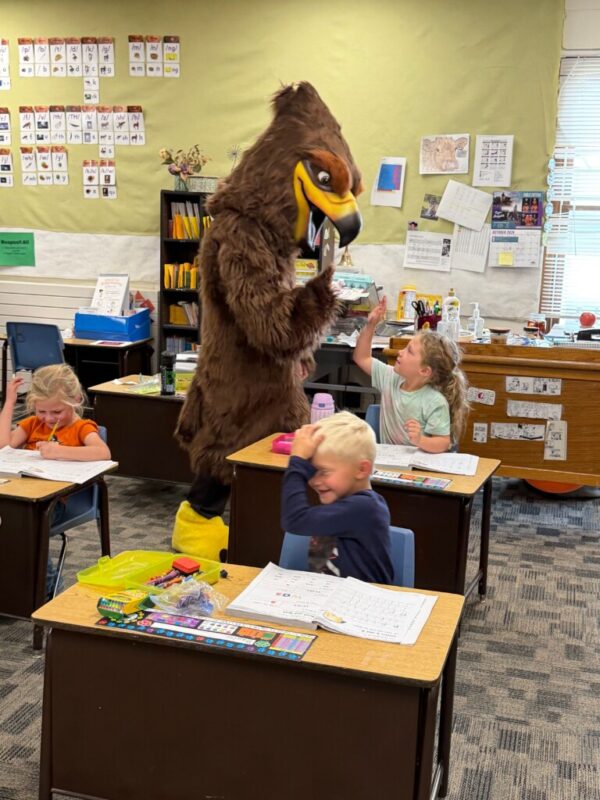 New Hawk mascot giving female student a high-five